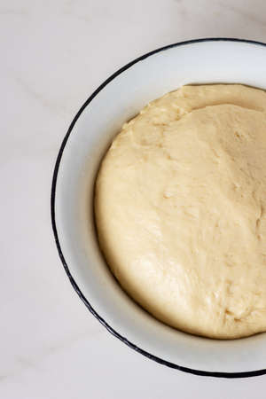 Homemade yeast fresh raw dough in bowl ready to bake.の写真素材