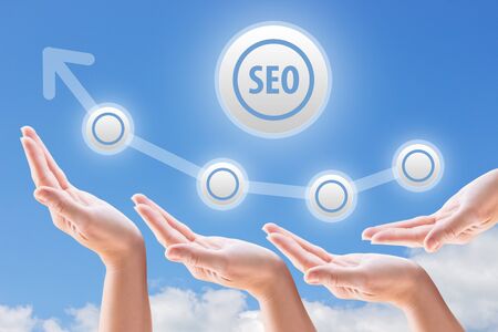 hands support the growth and promotion seo on the background of sky and cloudsの写真素材