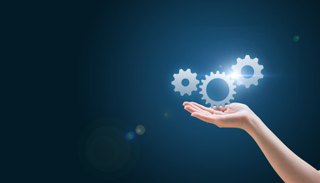 hand hold gear on a blue background, management conceptの写真素材