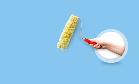 To make repairs in the house. The hand holding the roller for repair of the walls.の写真素材