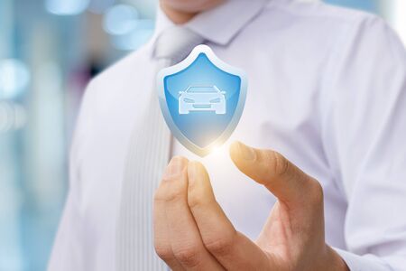 Car insurance for the protection. The shield with the car in the hand of the lawyer.の写真素材