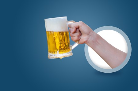 Glass of beer in hand isolated on white background .の写真素材