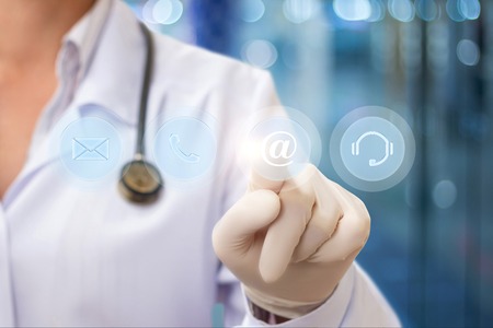 Doctor pressing the email button on blurred background .の写真素材