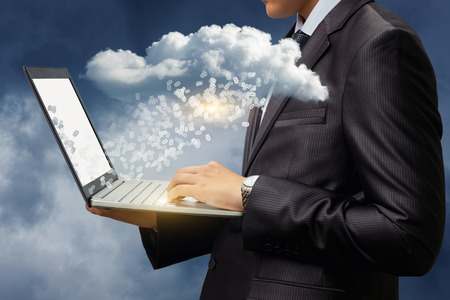 Businessman download letters from the data cloud in the sky.の写真素材