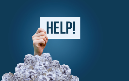 A sign saying help in a pile of garbage on blue background.
