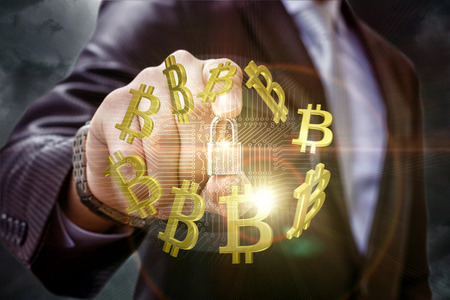 Businessman puts protection on trafficking in bitcoins. Concept design.の写真素材