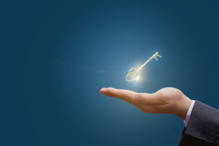 In hand the key to success in business on a blue background.の写真素材