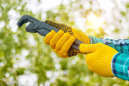 Wrench in hand on a blurred background.の写真素材