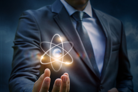 Businessman showing an atom in the sky.の写真素材