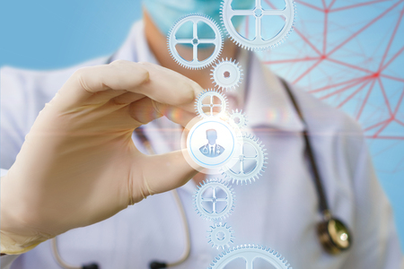 Doctor puts a icon of a doctor to the mechanism. The concept of choice of doctor for treatment.の写真素材