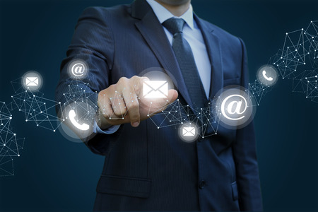 Businessman clicks on the letter. Concept contact us.の写真素材