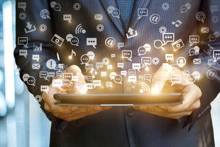 Tablet showing a holographic image of social media icons. A concept design.の写真素材