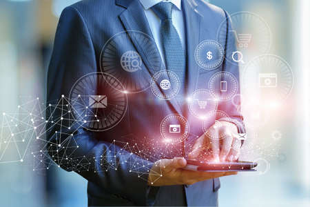 Businessman on tablet deals online marketing on blurred background.の写真素材