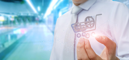 Businessman showing a shopping cart on blurred background.の写真素材