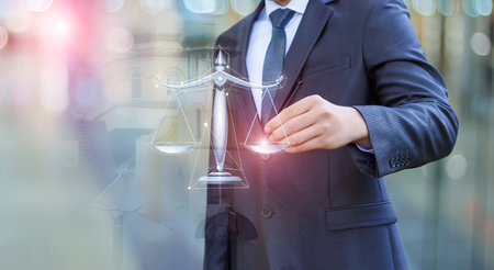 Lawyer draws the scales of justice on blurred background.の写真素材