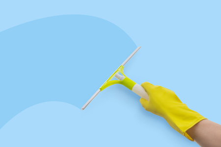 Employee of the service cleans the glass on a blue background.の写真素材