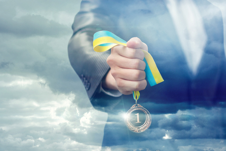 Medal leader in businessman hand on background of the sky.の写真素材