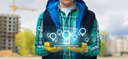 Builder with tablet and points the location of real estate in the network.