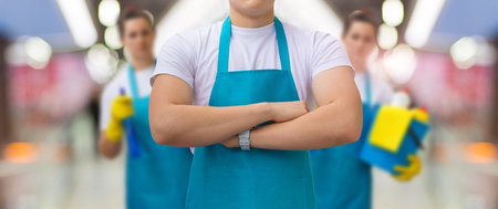 Group of cleaners standing on blurred background. Concept cleaning service.の写真素材