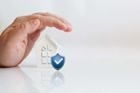 Hand house and shield. The concept of insurance or protection of property.の写真素材