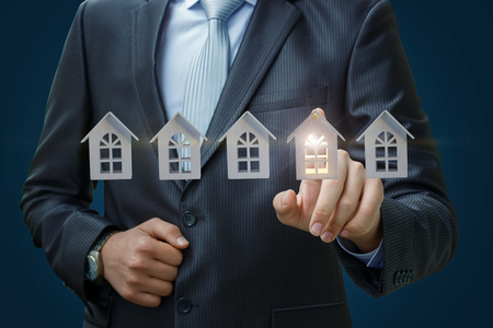 Businessman selects a property on a blue background.の写真素材