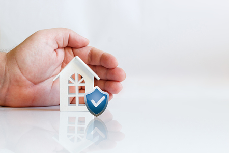 Hand the agent the house and the shield. The concept of protection and property insurance.の写真素材