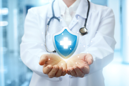 Medical worker shows the symbol of health on blurred background.の写真素材