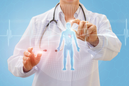Doctor examining hologram of a person on a blue background.の写真素材
