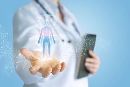 Doctor shows the scanning of a hologram of a person on a blue background.の写真素材