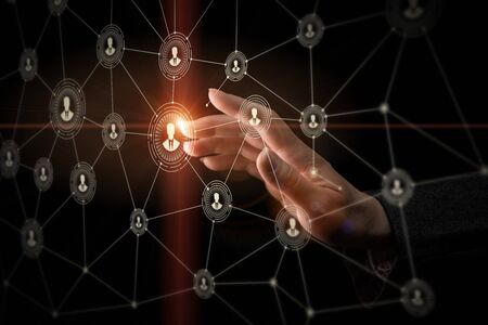 Hand pressing social media icon on a dark background.の写真素材