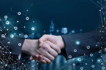Handshake on the background of night streets of the city.の写真素材