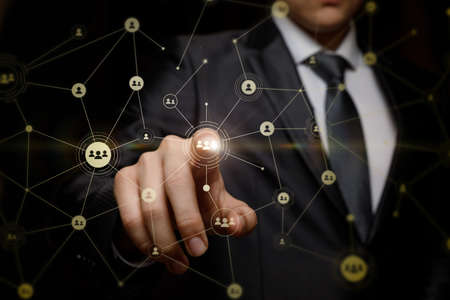 Businessman clicks on the avatar in the network on a dark background.の写真素材