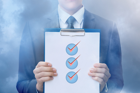 Check list in the hands of a businessman in the sky.の写真素材