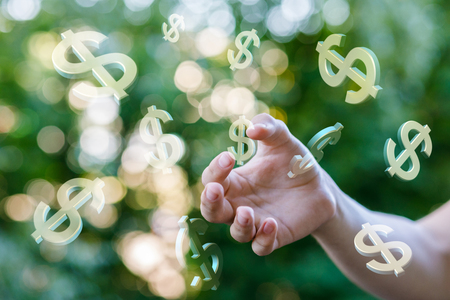 Hand is touching the dollar sign on blurred background.の写真素材