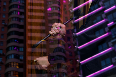 Thief with a crowbar trying to break in on the background of a multistory building.の写真素材