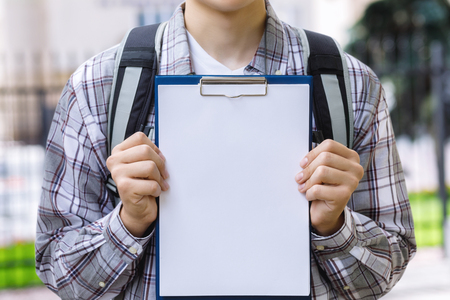 Student shows check list on blurred background.の写真素材