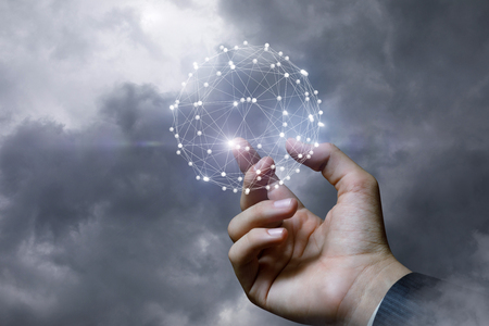 Hand of a businessman shows the network against the sky.の写真素材