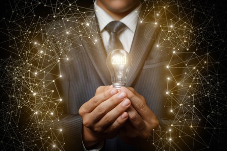 2019 light bulb as an idea in the hands of the businessman. The concept of a new year.の写真素材