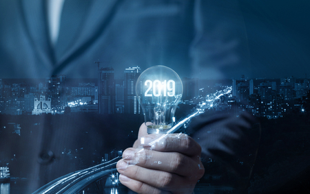 Businessman showing light bulb with glowing 2019. The concept of a new business year.の写真素材