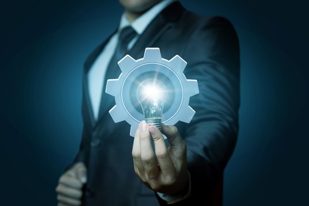 Bright innovative idea in hand businessman on blue background .の写真素材