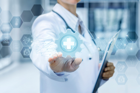 Doctor clicks on medical equipment icon on a blue background.の写真素材