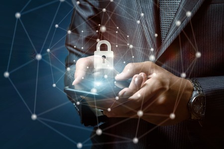 Businessman puts a security lock in the phone on a blue background.の写真素材