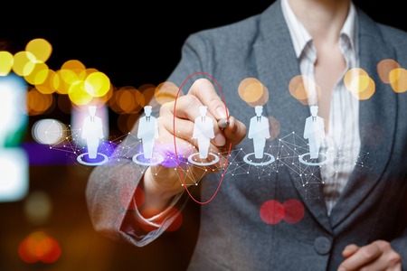 Businessman chooses the candidate on the background of night city.の写真素材