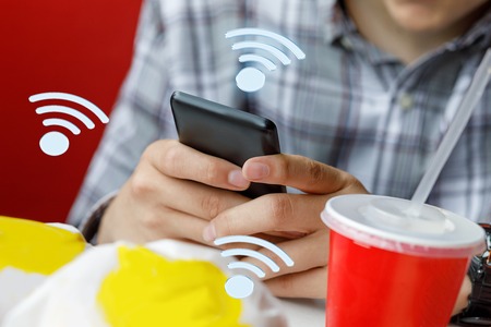 Man in a cafe chooses wifi to connect with your phone.の写真素材