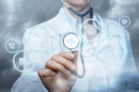 The qualified doctor is showing the icons with the different images inside symbolizing the compound organization of medical system. The concept is the health service mechanism meaning.の写真素材