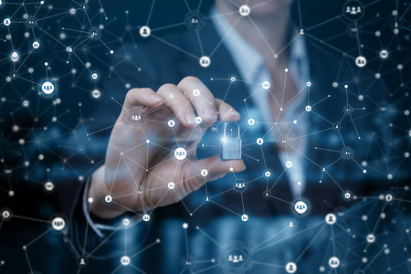 A businesswoman is showing a padlock between her fingers at the wireless connections foreground. The concept is private business security principle.の写真素材