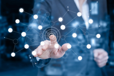 A businesswoman is touching a button of the wireless connections scheme at the touching screen. The concept is business connectivity principle.の写真素材
