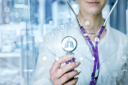 A closeup of doctor touching composite medical service system of icons and symbols with lungs model...