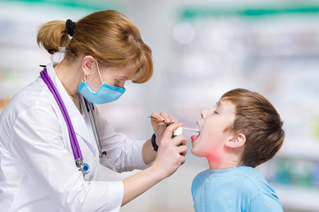 A closeup of children playing patient and pediatrician who is touching a toy bear with her stethoscope while sitting opposite each other at the blurred background. The pediatrician medicine concept.の写真素材