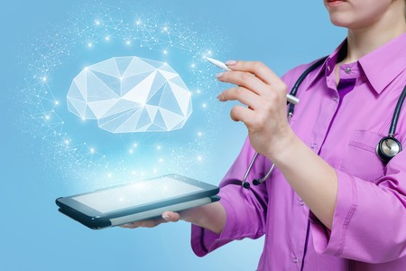 A closeup of a psychologist operating with a digital brain model hanging above a device. The concept...